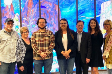 Award recipients, donor family, and university librarian in front of stained-glass mural