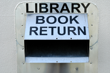 Metal library book drop slot on a wall